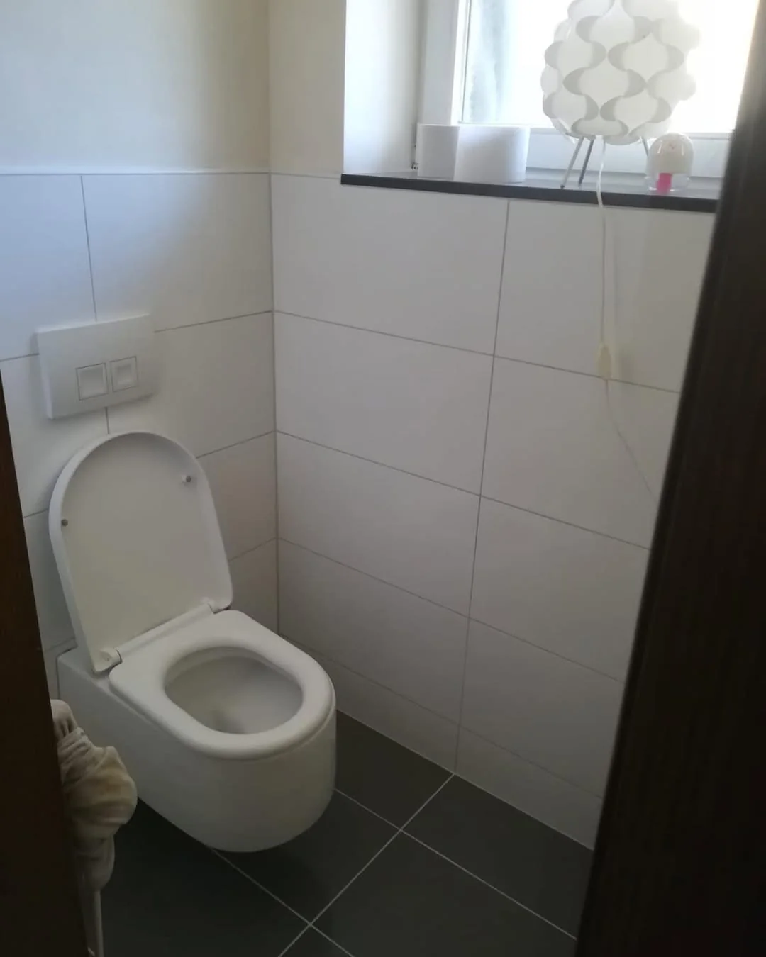 Modernes Gäste-WC mit Wand-WC und neuen Fliesen